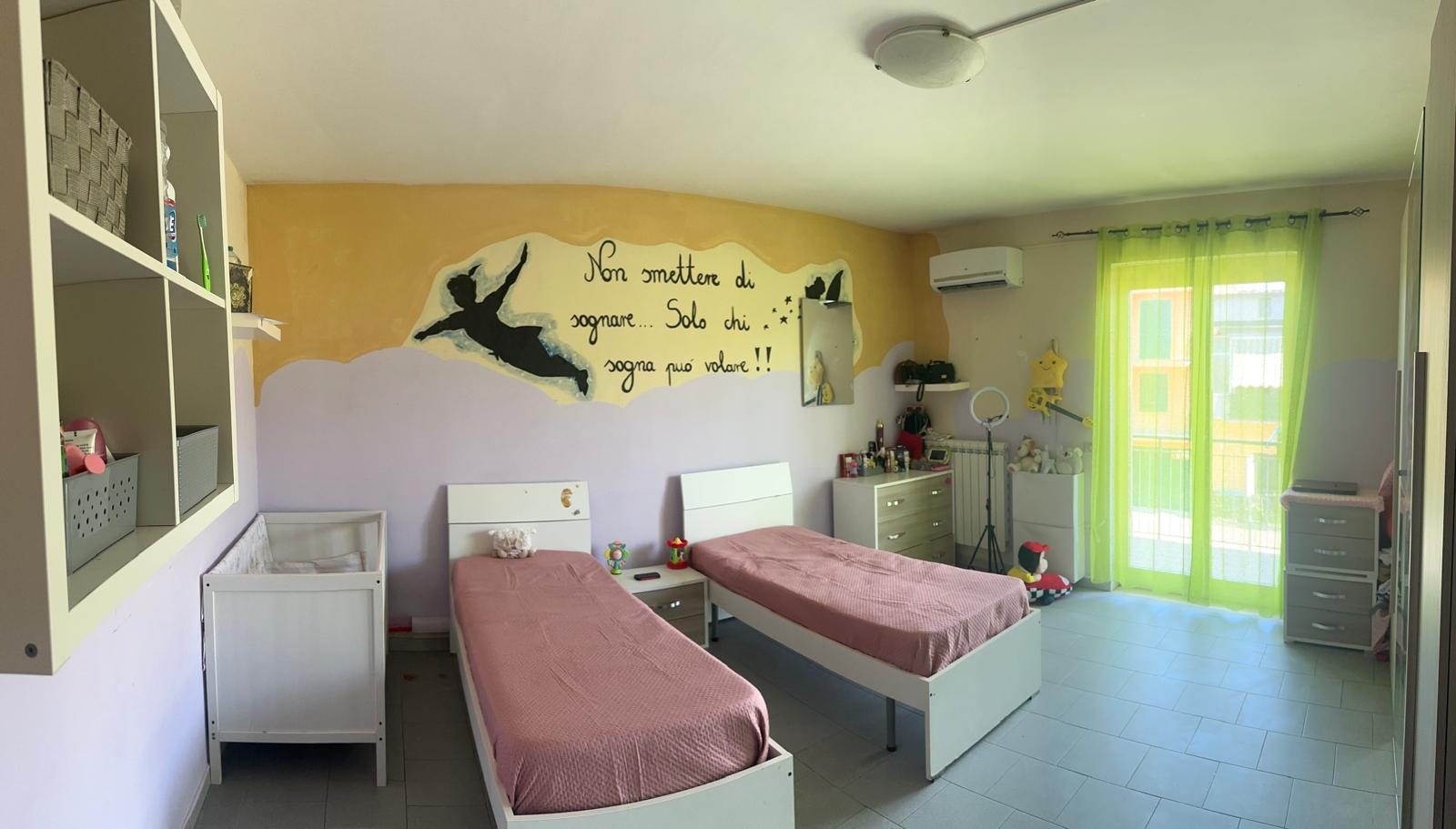 Cameretta con due letti singoli e scritta motivazionale a parete nella comunità Casa Mia