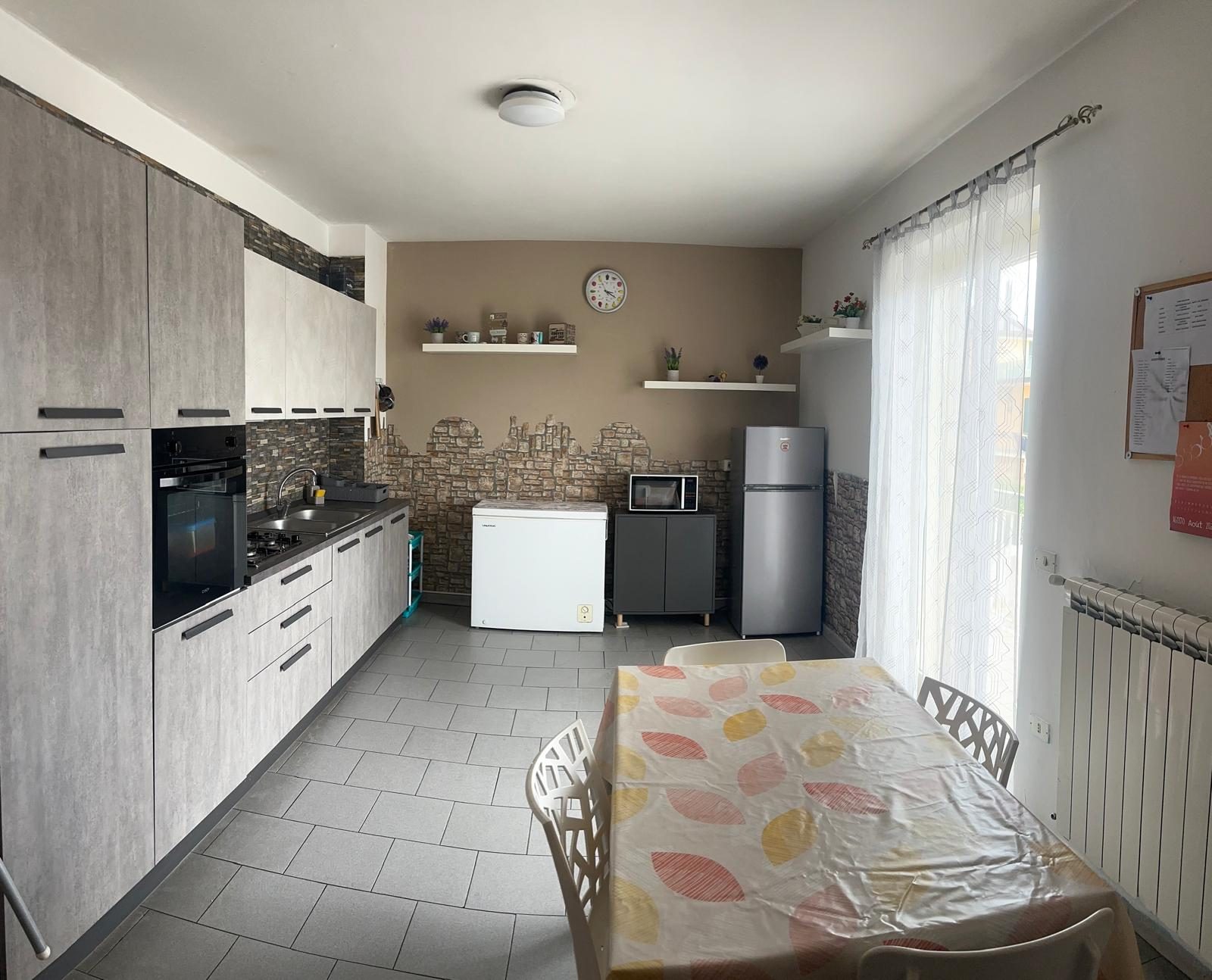 Cucina attrezzata con tavolo apparecchiato nella comunità Casa Mia