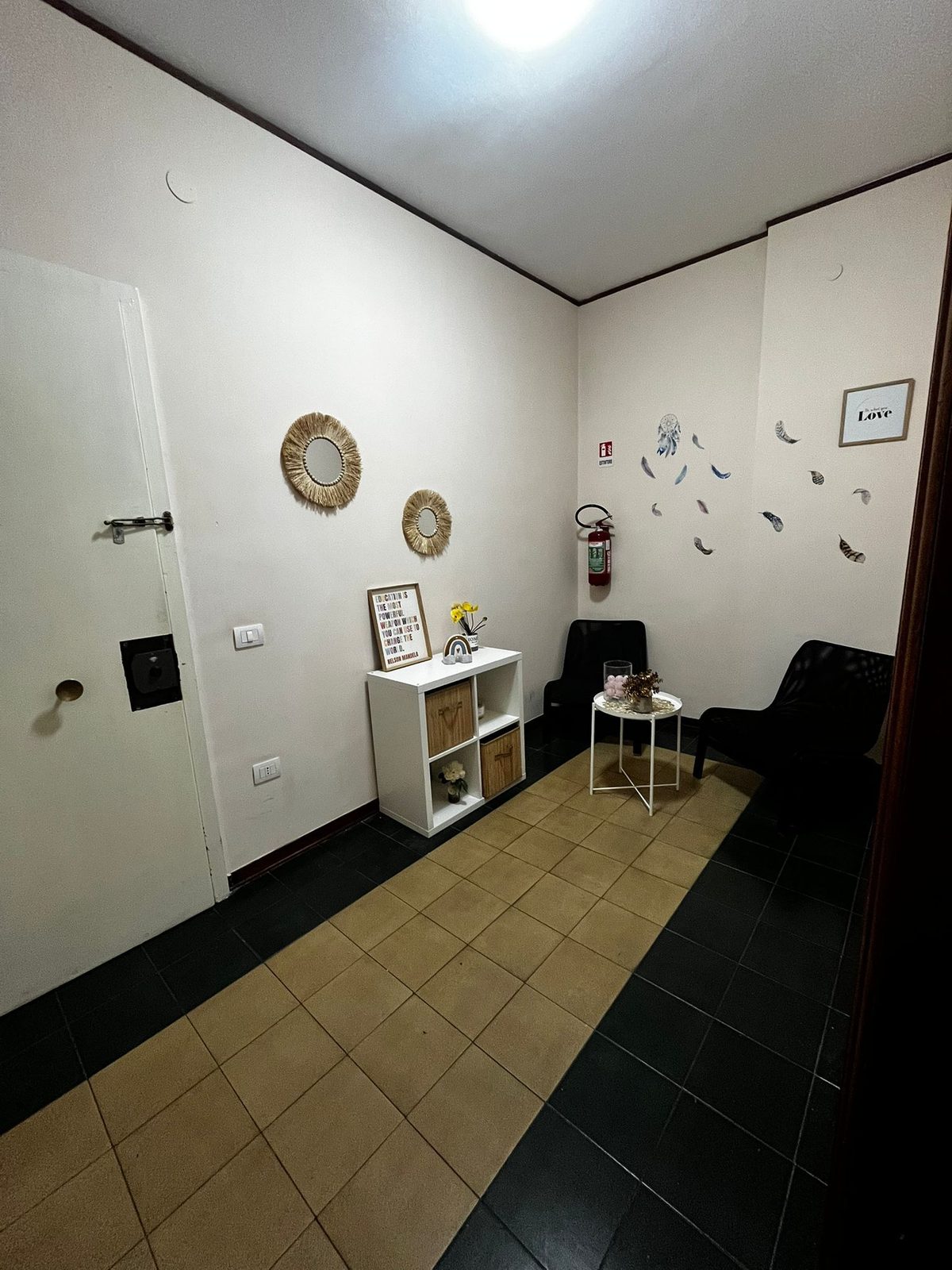 Zona relax all’ingresso con poltrone e specchi decorativi nella comunità L’Approdo