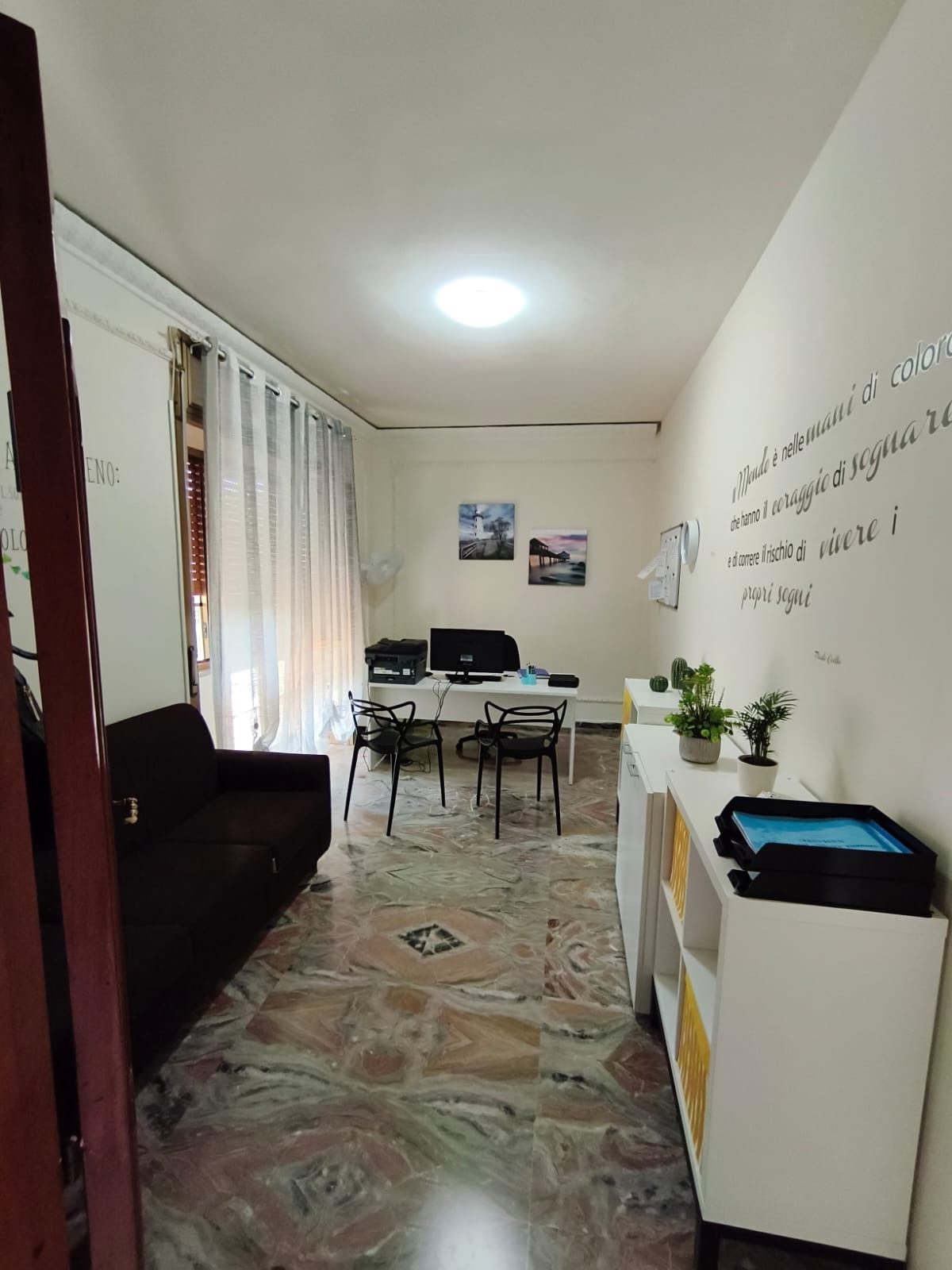 Ufficio con scrivania, divano e scritta motivazionale a parete nella comunità Namasté