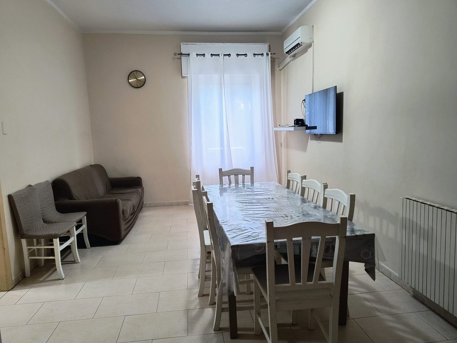Soggiorno con divano, tavolo da pranzo e TV nella comunità Piccoli Eroi